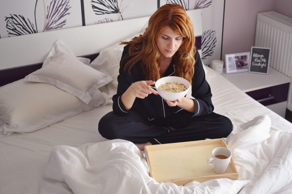 Kvinde der spiser i sengen.
