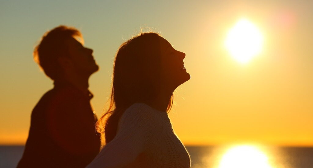 En mand og kvinde smiler mod solen.
